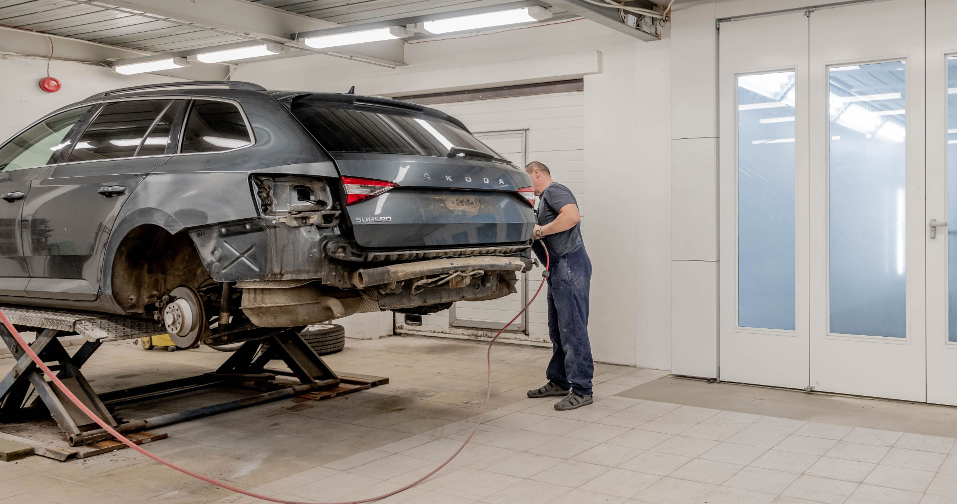 Auto body technician repairing the rear structure of a vehicle in a professional body shop