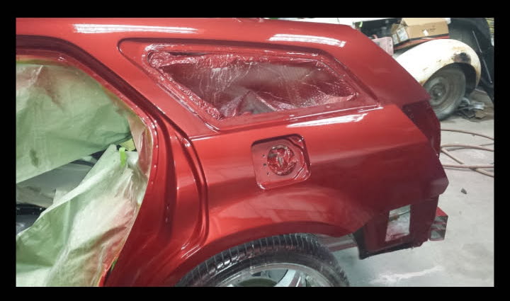 Red rear quarter panel refinished after collision body repair