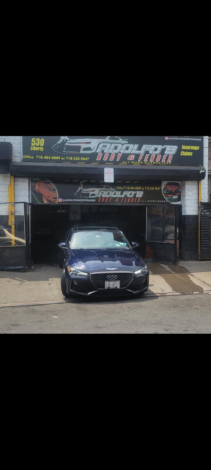Blue sedan parked at the entrance of Adolfo's Auto Body after service
