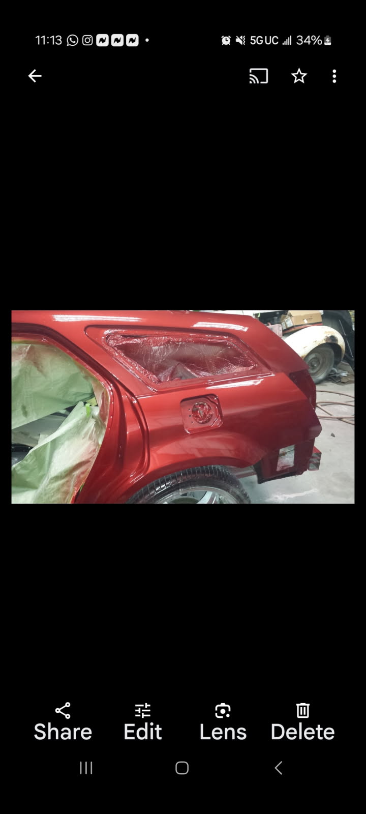 Red classic car body panel prepared for refinishing inside Adolfo's Auto Body