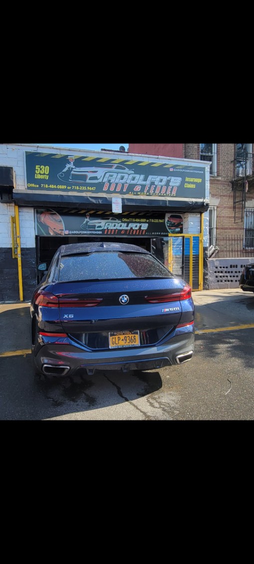 Blue sedan after auto body repair at Adolfo's Liberty Avenue storefront