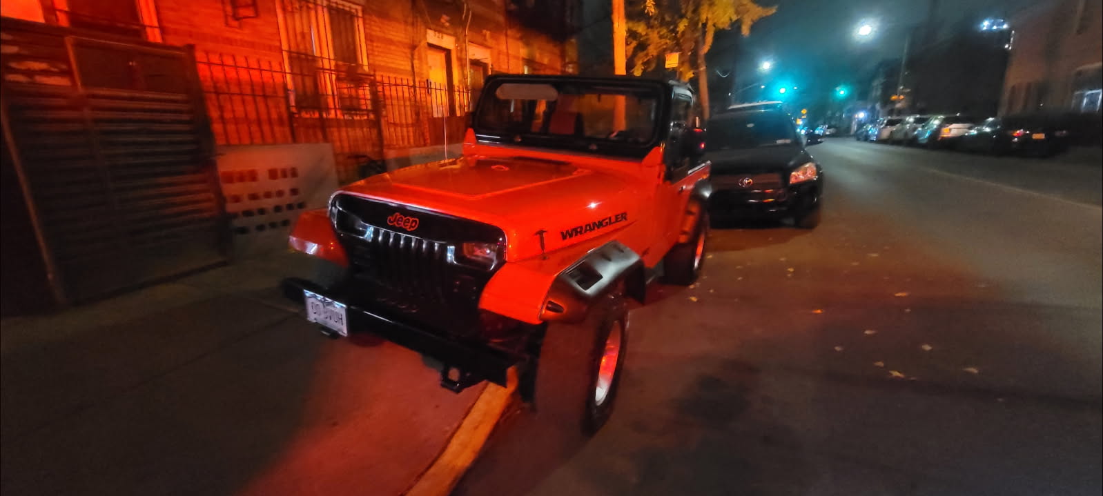 Orange off-road vehicle parked near Adolfo's Auto Body in Brooklyn