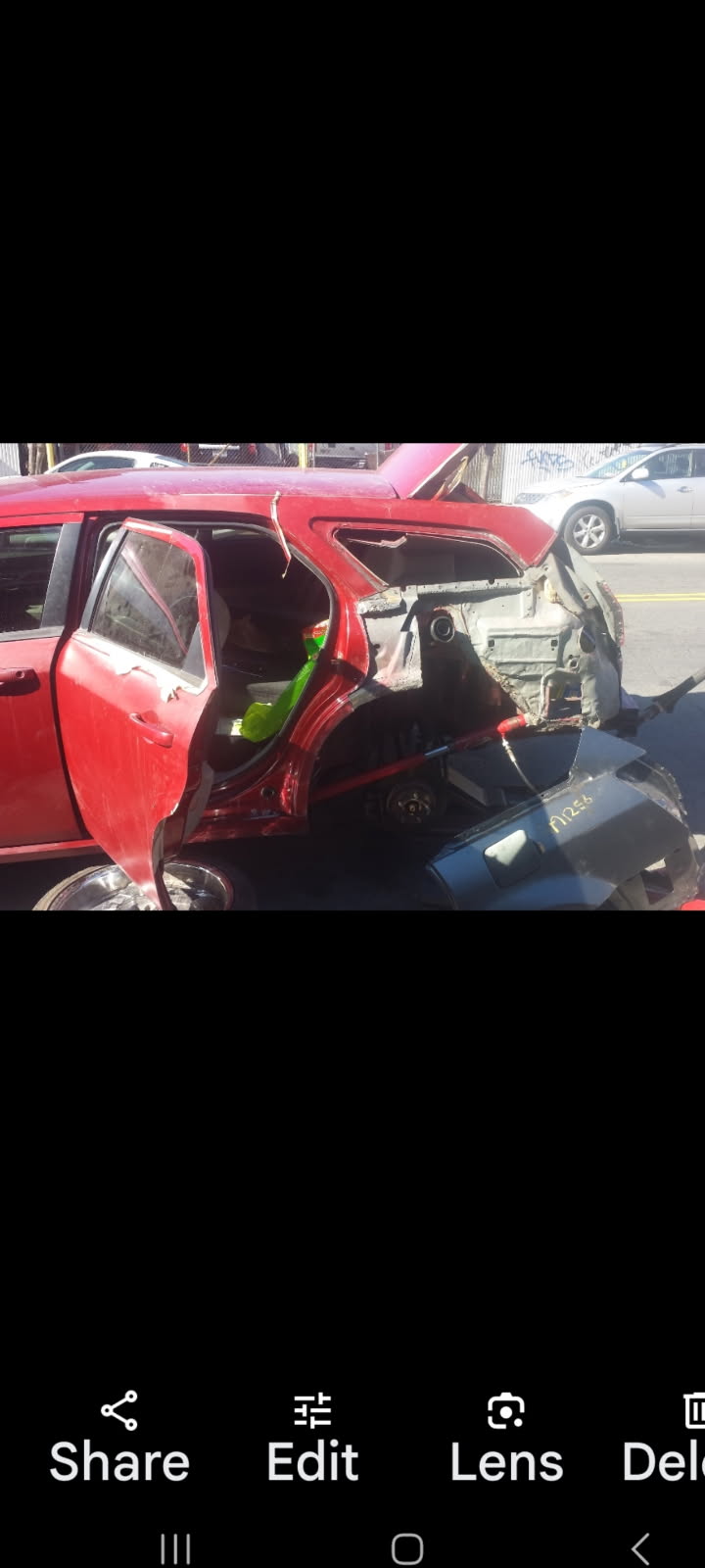 Red collision-damaged vehicle undergoing interior and body repair